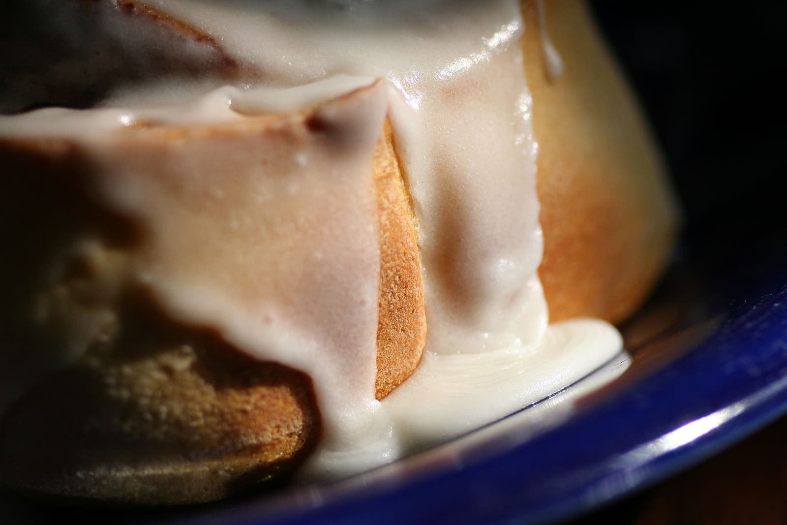 A cinnamon roll piled with fluffy white marshmallow frosting.