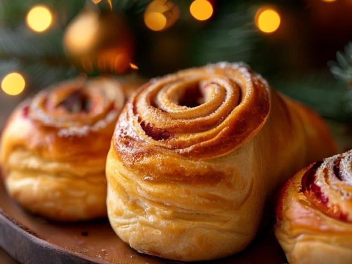 a single glazed cinnamon roll with green sugar and festive sprinkles lifted from a tray (AI-generated editorial image)