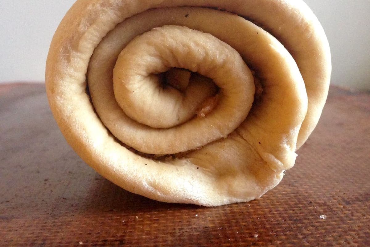 baking powder dough being patted out and spread with cinnamon sugar (AI-generated editorial image)